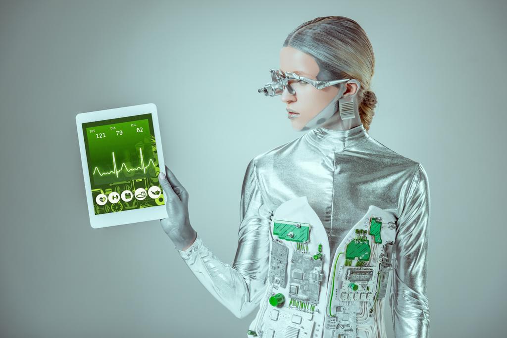 срібний робот дивиться на планшет з медичним приладом ізольовано на сірому, концепція майбутніх технологій
 - Фото, зображення