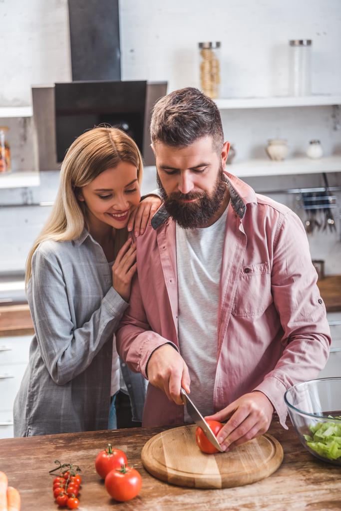 Σύζυγος και η σύζυγος στέκεται στην κουζίνα και την προετοιμασία σαλάτα - Φωτογραφία, εικόνα