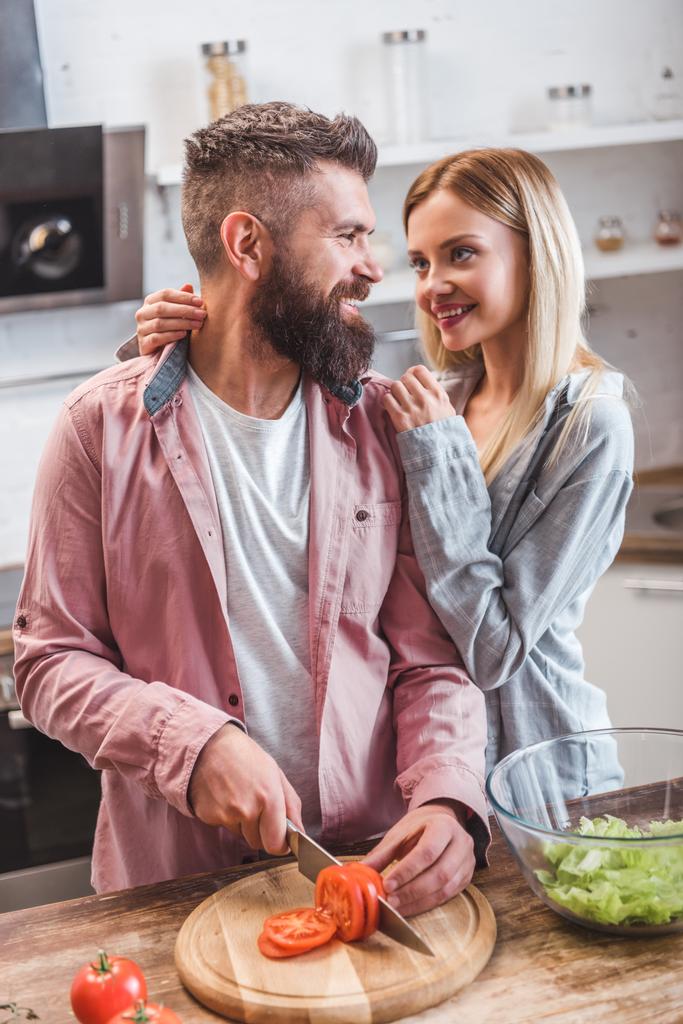 陽気なカップルが台所で夕食の準備  - 写真・画像