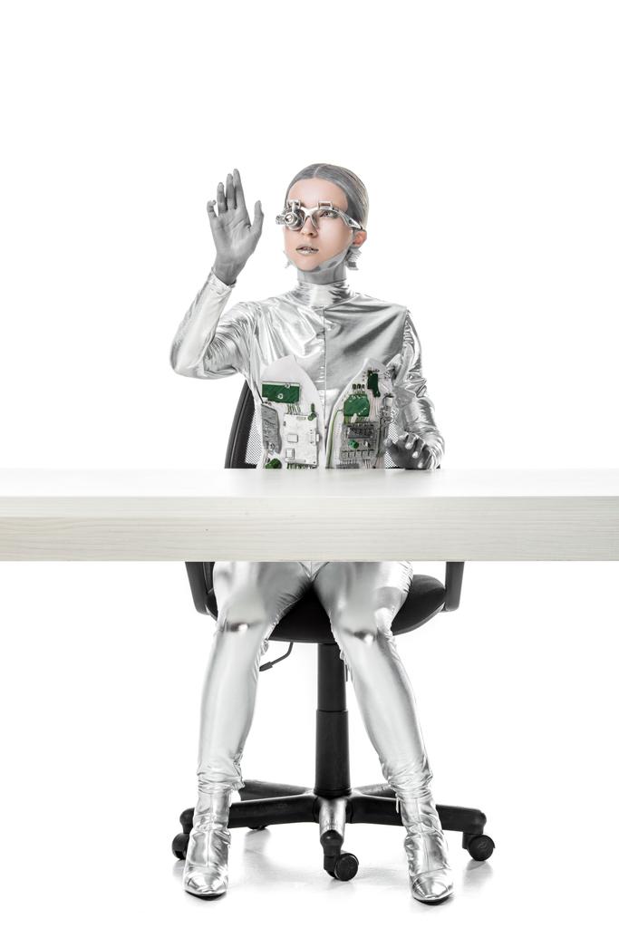 Cyborg sedí u stolu a něco izolovaných na bílém, budoucí technologický koncept dotýká  - Fotografie, Obrázek