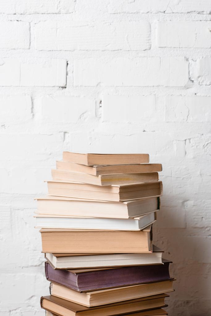 pile of books near white brick wall with copy space - Photo, Image
