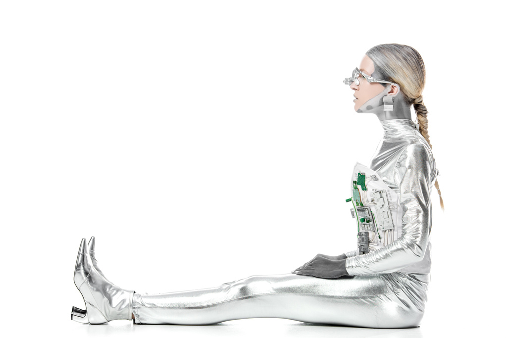 side view of silver robot sitting and looking away isolated on white, future technology concept - Photo, Image