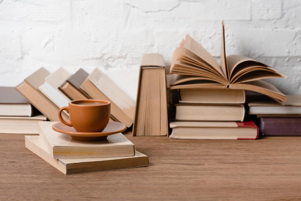 Boeken en kopje koffie op houten tafel - Foto, afbeelding