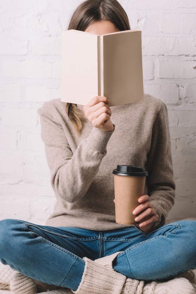 meisje holding boek en koffie om te gaan in de papier beker - Foto, afbeelding