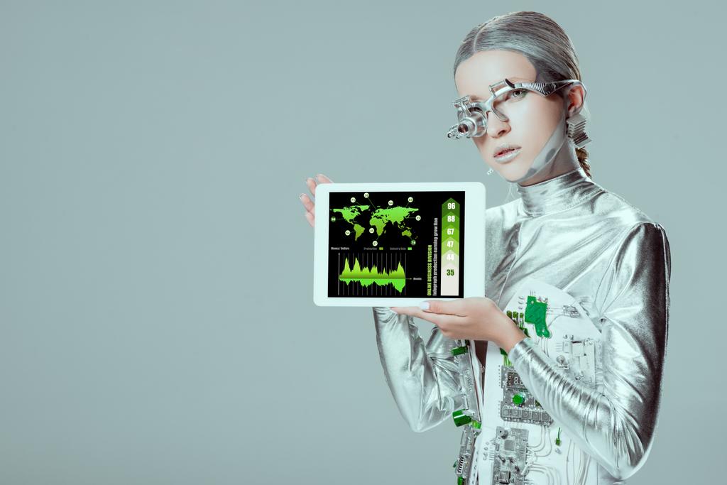 Серебряный робот держит планшет с онлайновым бизнес-устройством, изолированным на сером, концепция технологии будущего
 - Фото, изображение