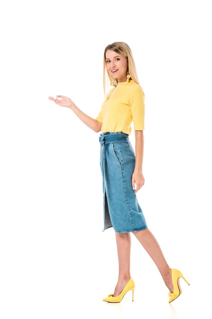 sorridente donna attraente in camicia gialla mostrando qualcosa di isolato sul bianco
 - Foto, immagini