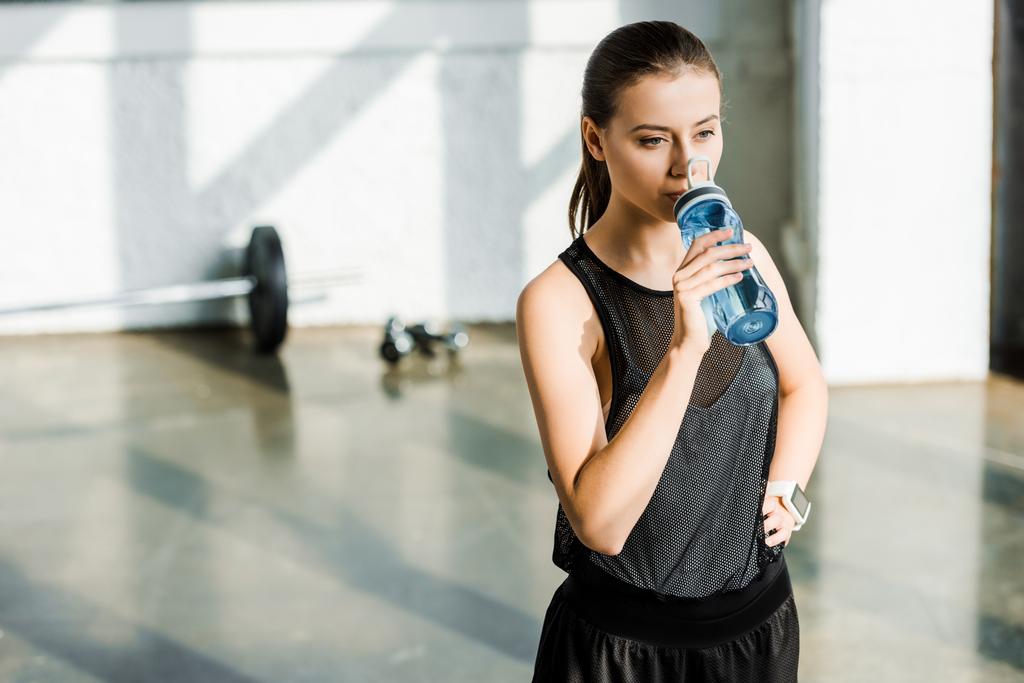 krásné koncentrované sportovkyně pitnou vodu z láhve sport v tělocvičně - Fotografie, Obrázek