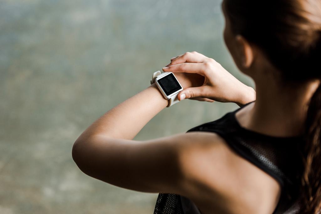 vista ritagliata di sportiva guardando smartwatch sport con schermo bianco in palestra
 - Foto, immagini