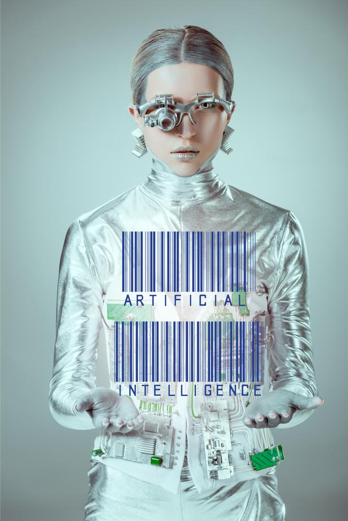 cyborg de plata futurista con códigos de barras e inteligencia artificial en las manos mirando a la cámara aislada en gris, concepto de tecnología futura
  - Foto, imagen