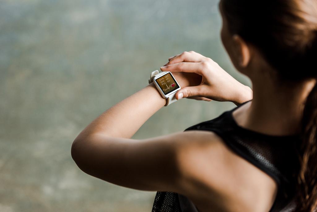 vue recadrée de sportive regardant sport smartwatch montrant rythme cardiaque à la salle de gym
 - Photo, image