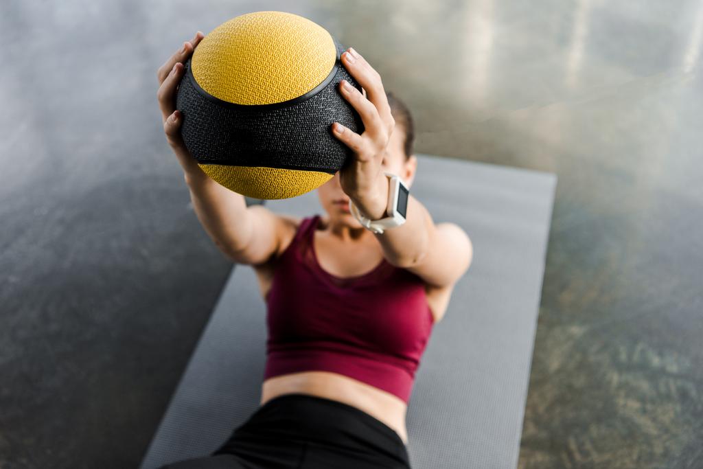 Sportlerin beim Fitnessmattentraining mit Medizinball im Fitnessstudio - Foto, Bild