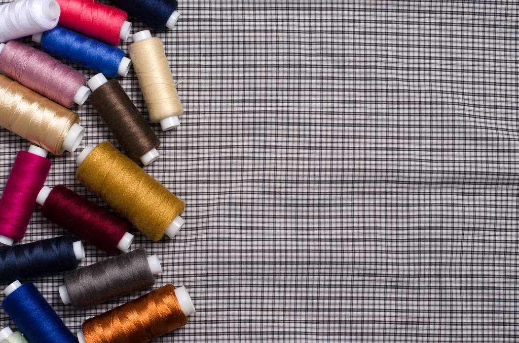 Nástroje a příslušenství pro šití. Barevný šicí vlákno na pozadí šedé textilní. Plochá horní pohled - Fotografie, Obrázek