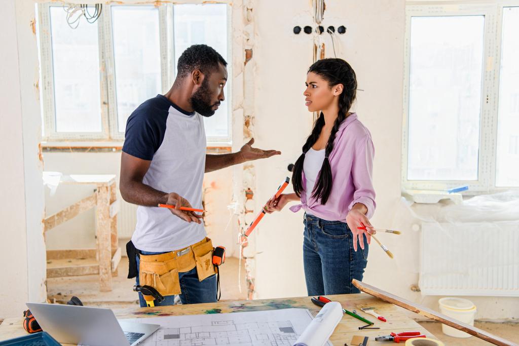 jonge Afrikaanse Amerikaanse echtpaar dat ruzie terwijl het maken van de renovatie van woning - Foto, afbeelding