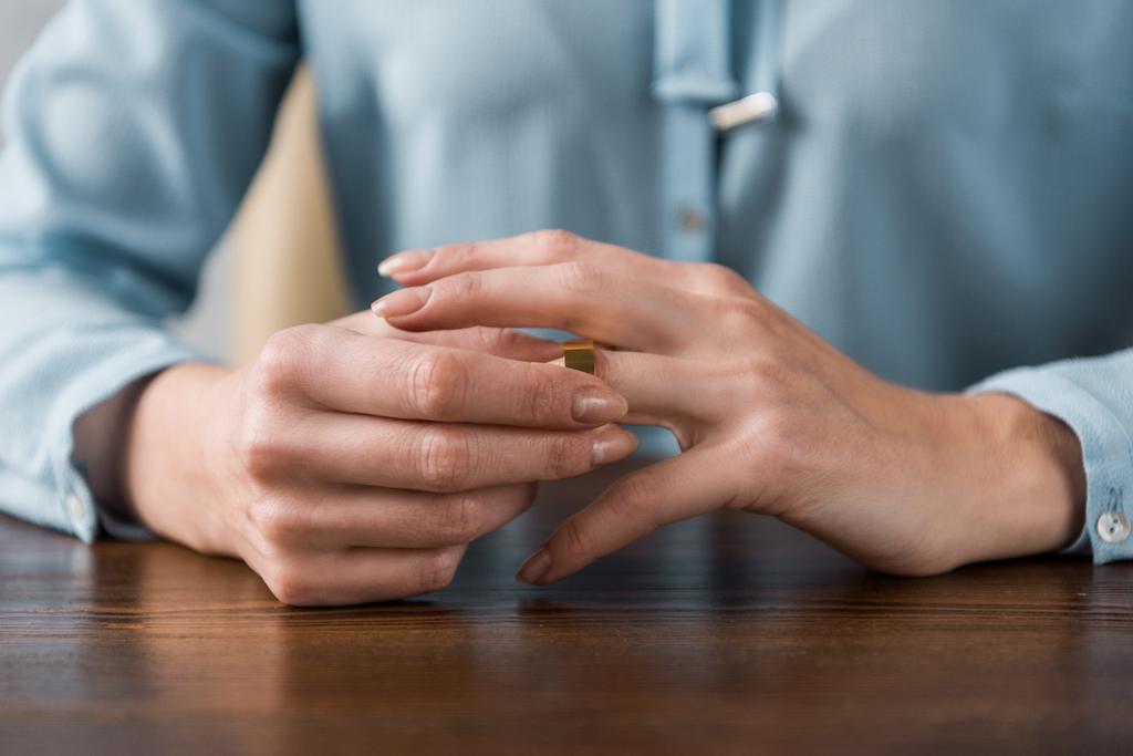 nő vesz ki esküvő gyűrű, válás fogalmát részleges kiadványról  - Fotó, kép