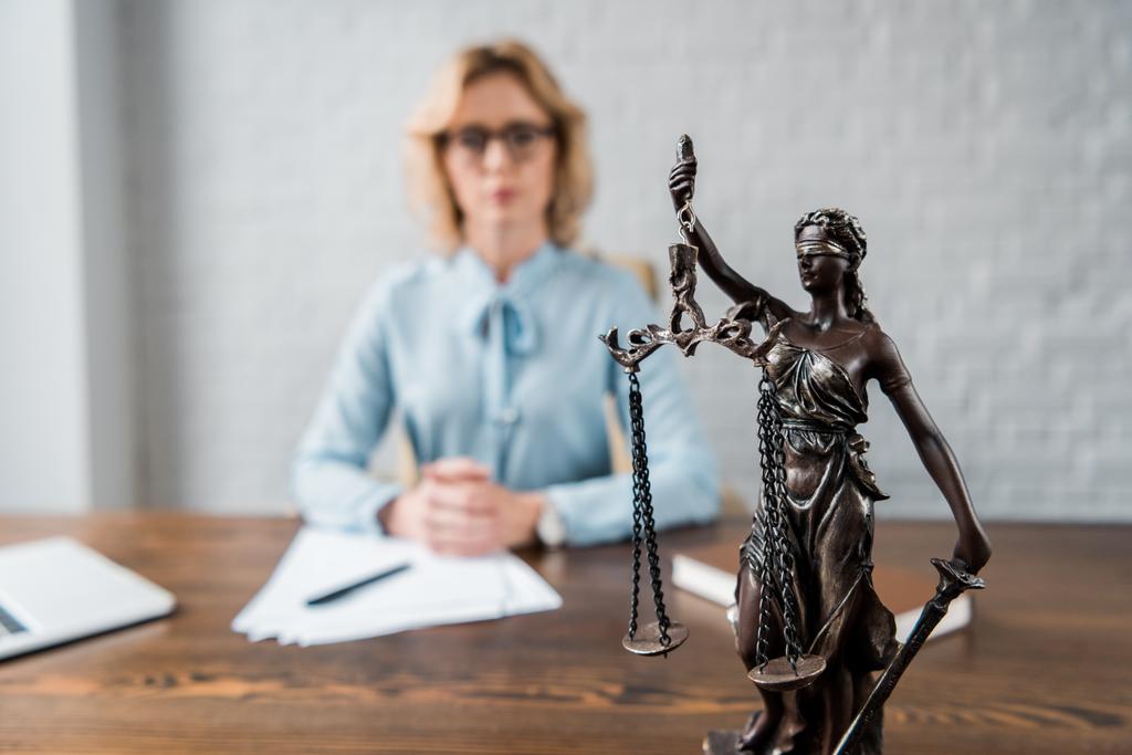 γκρο πλαν θέα κυρία δικαιοσύνης άγαλμα και γυναίκα δικηγόρος που εργάζονται πίσω από - Φωτογραφία, εικόνα