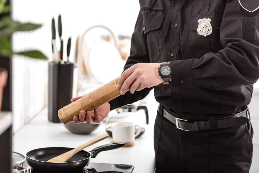 περικοπεί άποψη του αξιωματικού της αστυνομίας μαγείρεμα πρωινό στην κουζίνα - Φωτογραφία, εικόνα