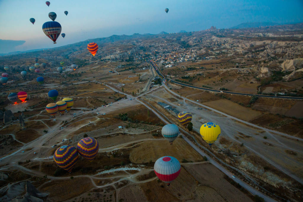 Καππαδοκία, Τουρκία: Μπαλόνια θερμού αέρα πετούν κατά τη διάρκεια της ανατολής του ηλίου στην περιοχή Καππαδοκία της Τουρκίας. Μπαλόνι κατά το μπλε του ουρανού κατά την πτήση, πολύχρωμο διασκεδαστικό τρόπο μεταφοράς διασκέδαση, πτήση στον αέρα του μπαλονιού, η έννοια του ονείρου και της ευτυχίας - Φωτογραφία, εικόνα