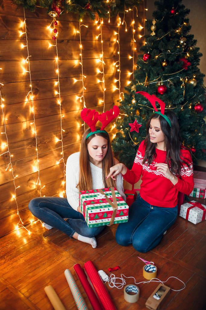 Jolies femmes préparant une boîte cadeau pendant Noël
 - Photo, image