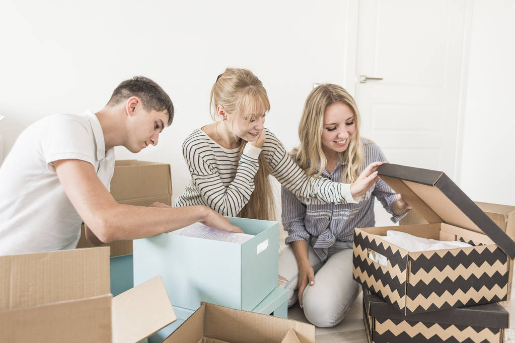 Familia desembalaje cajas de cartón en el nuevo hogar. mudarse a una casa nueva. concepto de una familia feliz y la inauguración de la casa
 - Foto, imagen