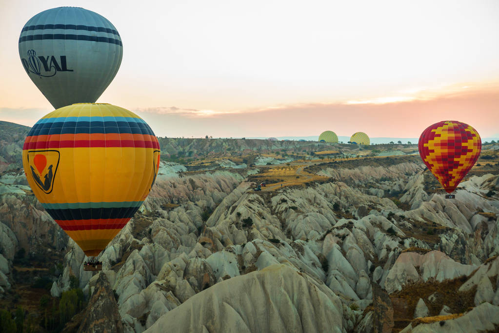 Muitos balões de ar quente coloridos voam acima das montanhas - panorama da Capadócia ao nascer do sol. Ampla paisagem do vale de Goreme na Capadócia - fundo de cartaz para o seu conceito de viagem na Turquia
. - Foto, Imagem