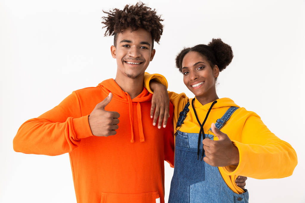 Image of pretty african american couple in colorful clothes showing thumbs up isolated over white background - Photo, Image