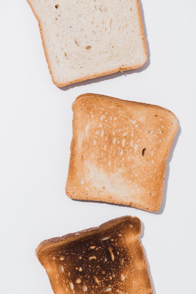 top view of toasts in various roast stages on white surface - Photo, Image