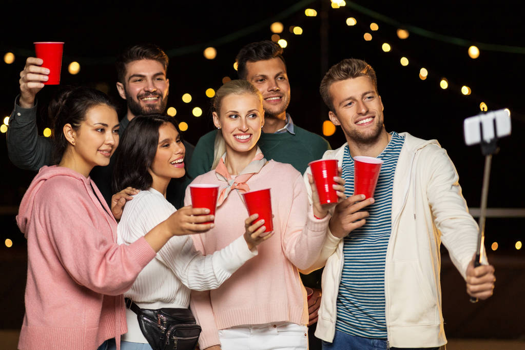 φίλοι με ποτά λήψη selfie σε πάρτι στον τελευταίο όροφο - Φωτογραφία, εικόνα