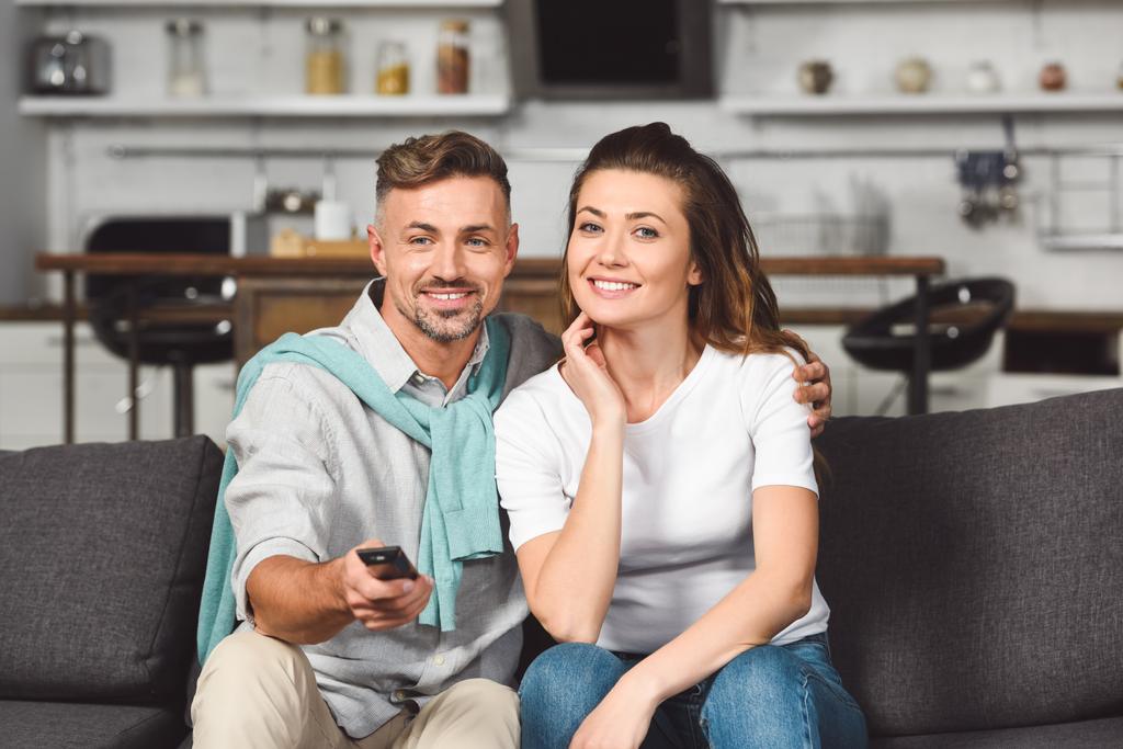man en vrouw zittend op de Bank en samen tv kijken - Foto, afbeelding