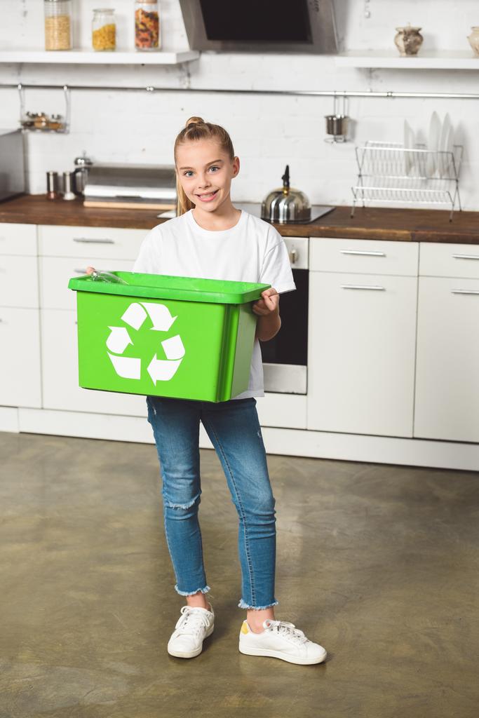 enfant souriant tenant boîte de recyclage verte à la cuisine
  - Photo, image
