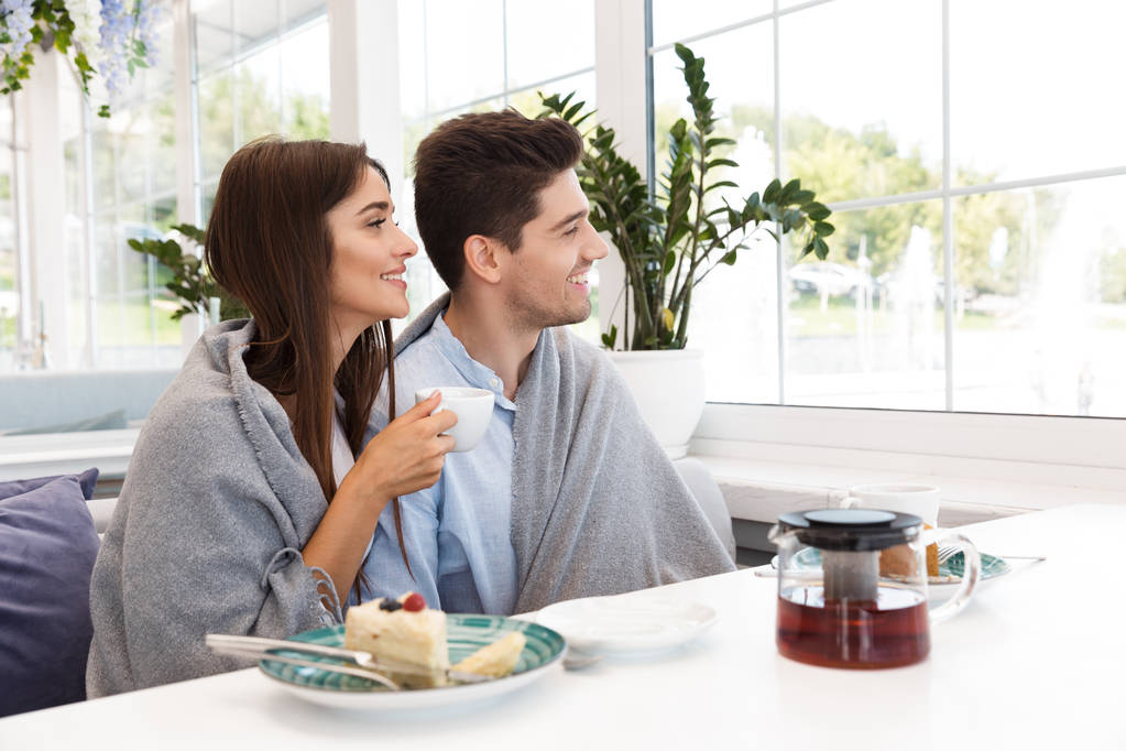 Immagine di sorprendente giovane coppia amorevole seduta nel caffè mangiare dolci e bere tè
. - Foto, immagini