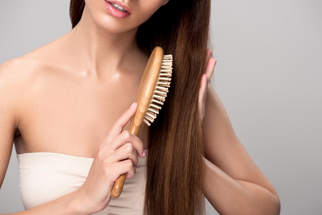 oříznutý pohled ženy česání vlasy s dřevěný kartáč, izolované Grey - Fotografie, Obrázek