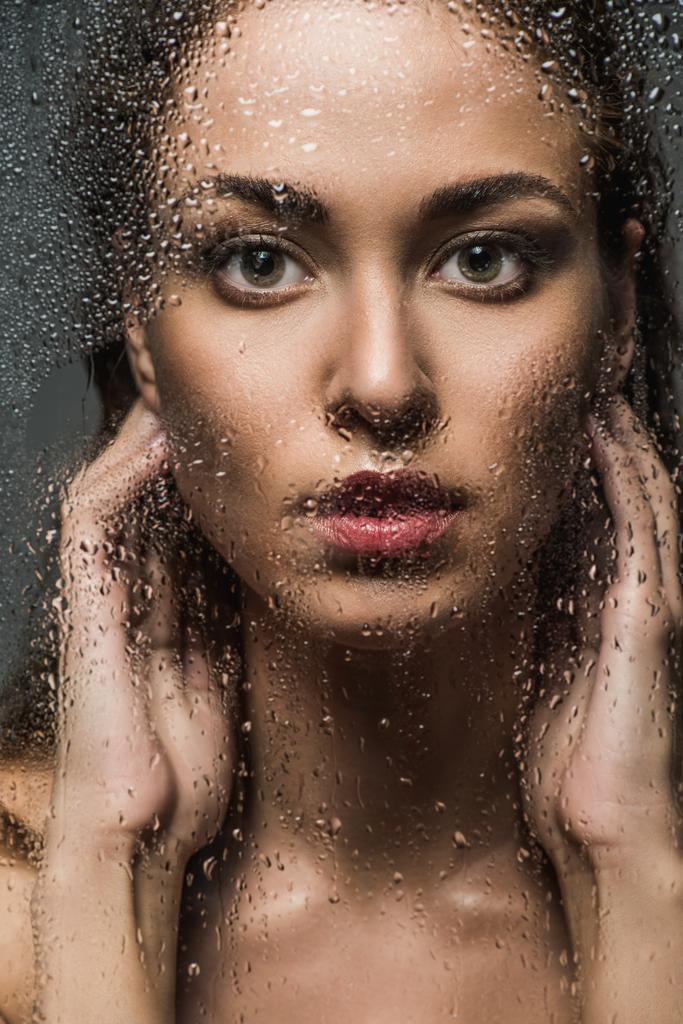 attractive tender girl behind wet glass in shower - Photo, Image