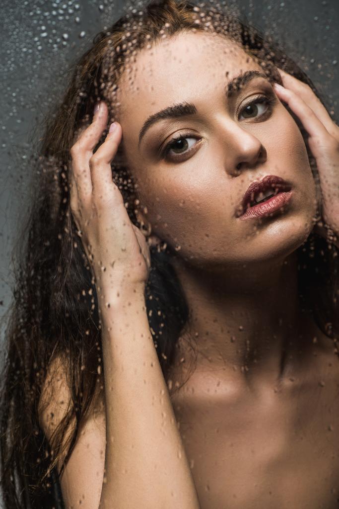 gyönyörű fiatal nő mögött nedves üveg csepp - Fotó, kép