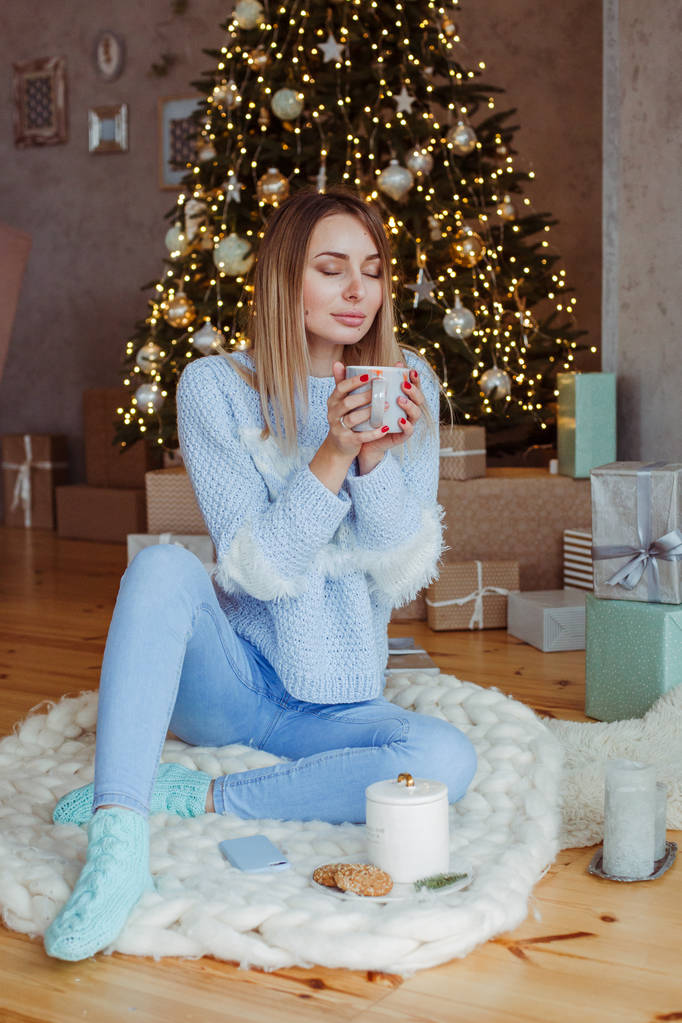 Mujer sosteniendo galleta de jengibre de Navidad y taza con cacao caliente
 - Foto, Imagen