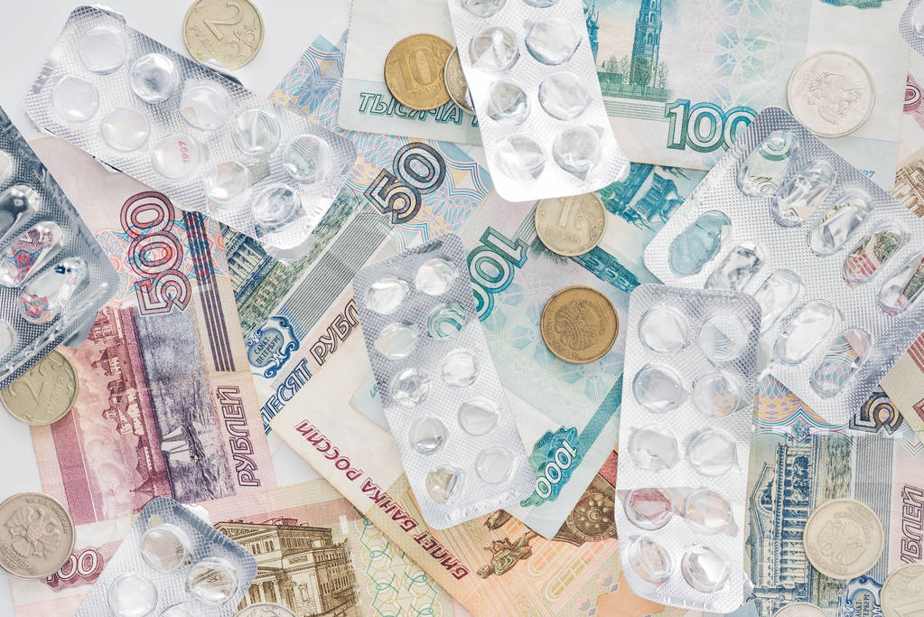 ylhäältä näkymä Venäjän käteistä rahaa ja tyhjiä pillereitä paketteja pinnalla
 - Valokuva, kuva