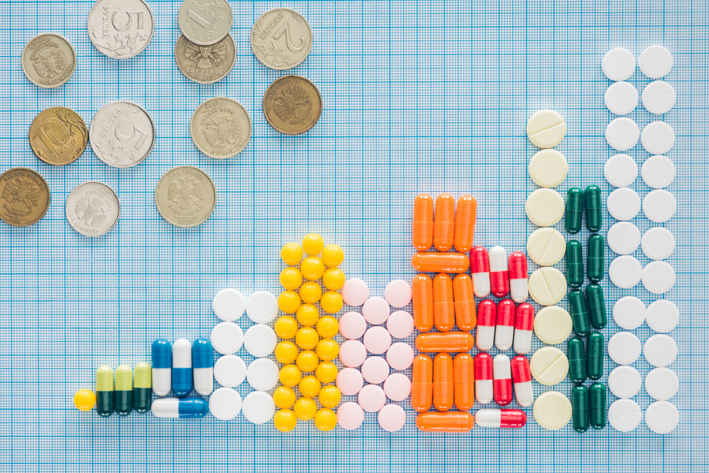 vue d'en haut des piles disposées de pilules colorées et de roubles russes sur une surface à carreaux bleus
 - Photo, image