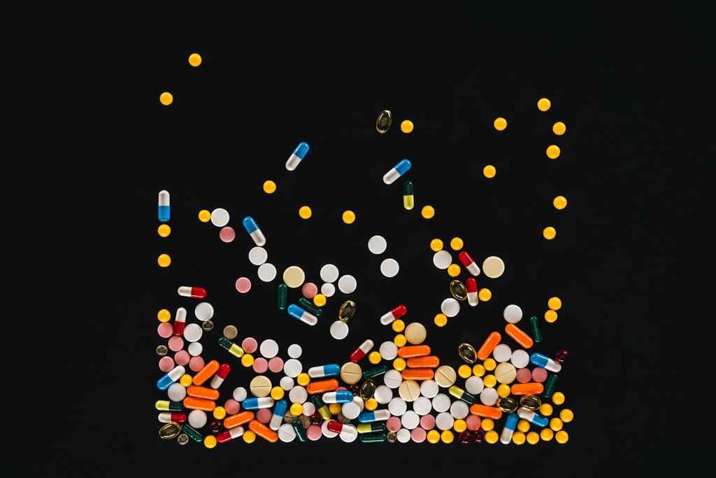 vista elevada de pila colorido varias píldoras aisladas en negro
  - Foto, Imagen