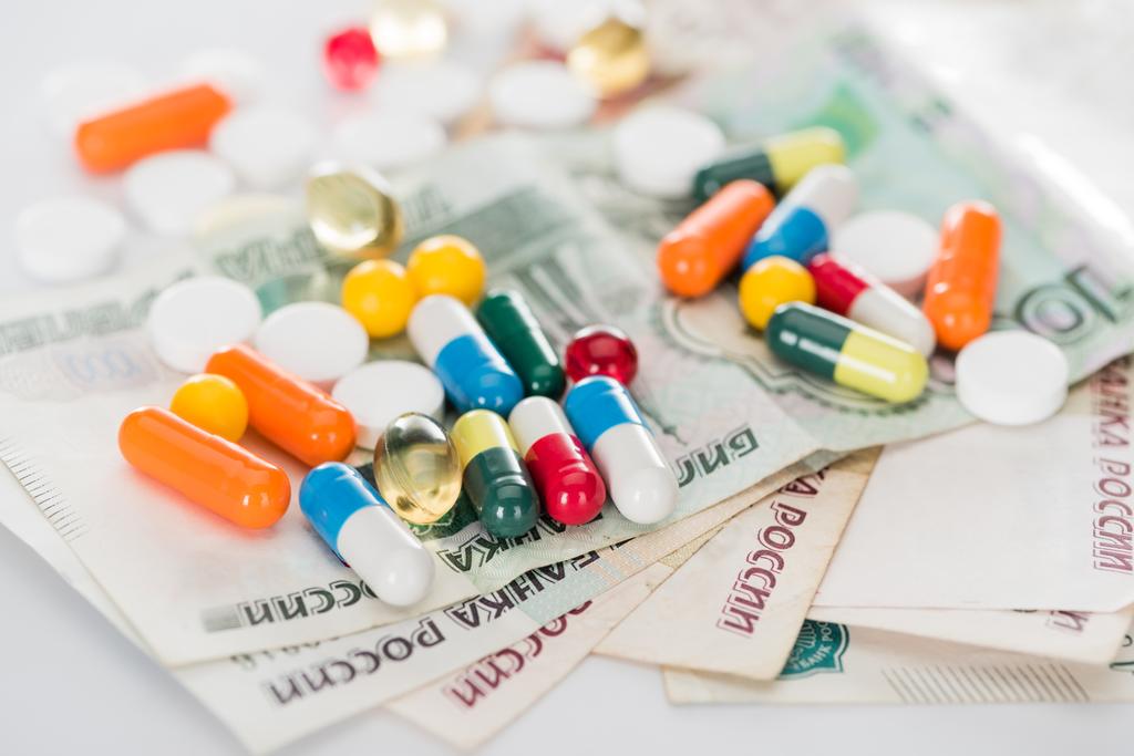 selective focus of colorful various pills and russian cash money on surface - Photo, Image