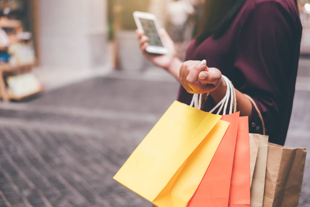Tüketim, alışveriş, yaşam kavramı, Genç kadın holding renkli alışveriş torbaları ve akıllı telefon Alışveriş keyfi. - Fotoğraf, Görsel