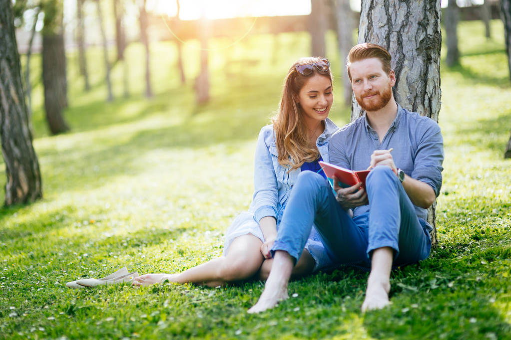 Beautiful couple studying together for exams in nature - Photo, Image