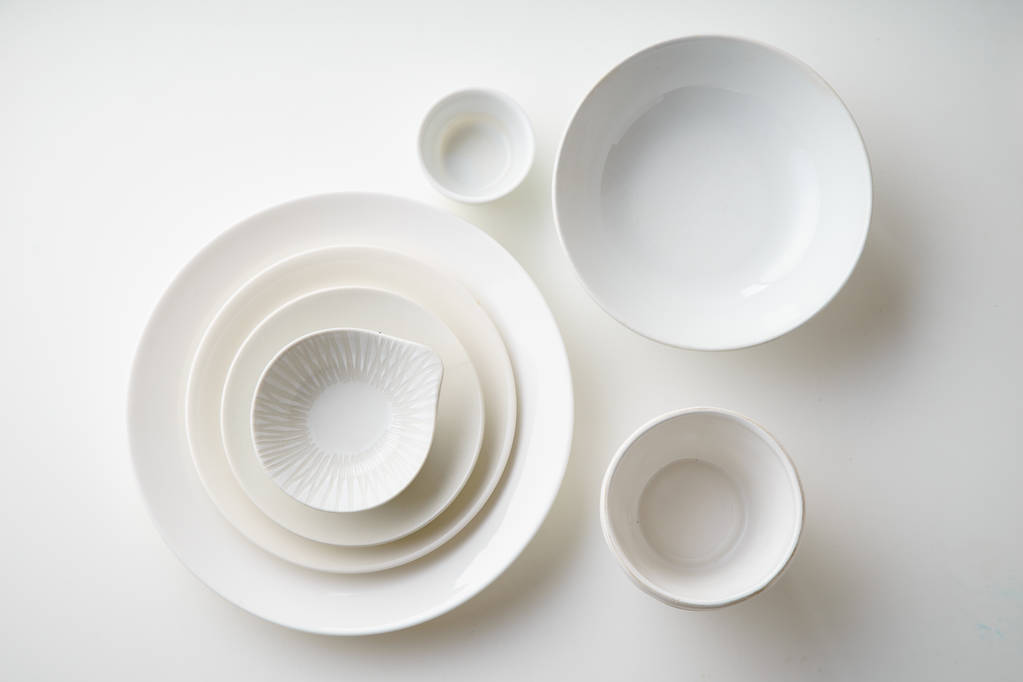 conjunto de platos de porcelana aislados sobre fondo blanco, primer plano
  - Foto, imagen