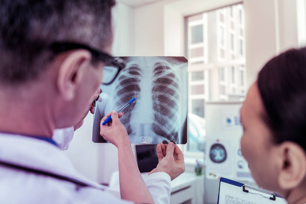 Двоє медиків обговорюють результати дослідження рентгена
 - Фото, зображення