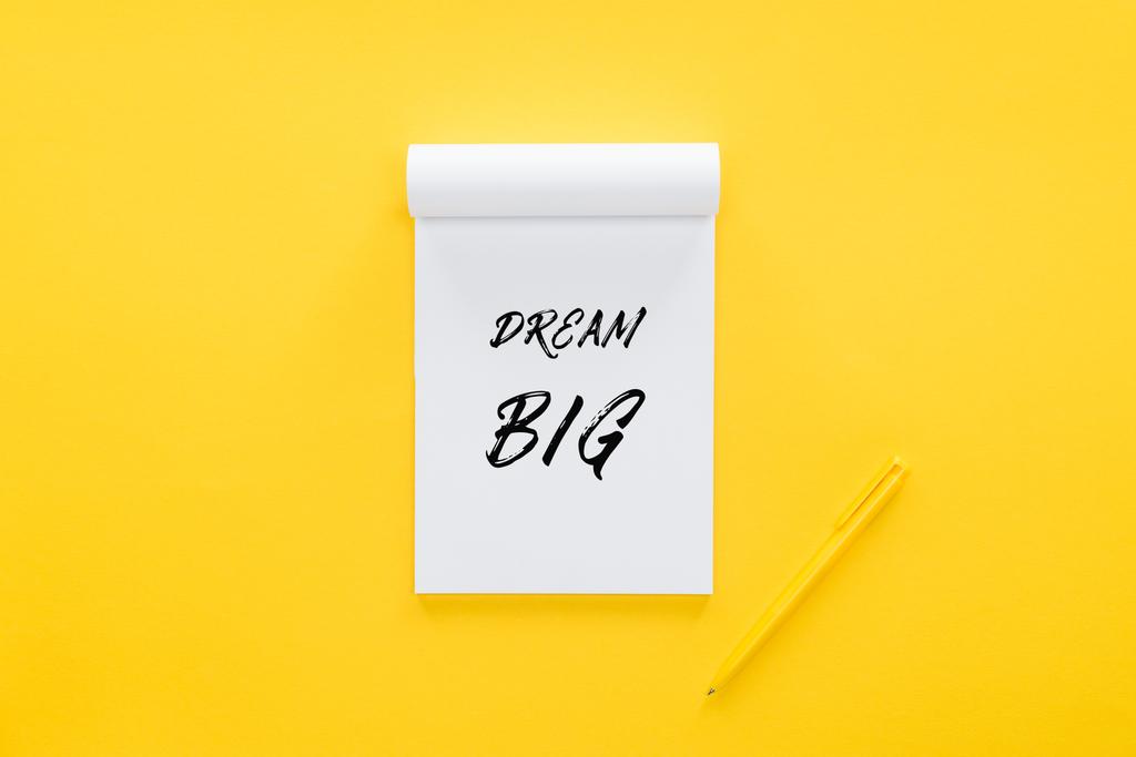 вид сверху тетради с цитатой "dream big" на желтом, концепция постановки целей
 - Фото, изображение