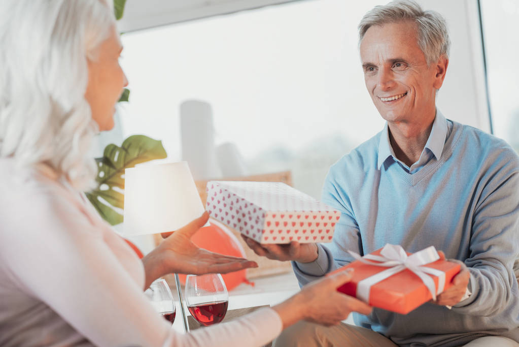 Portrait of senior couple presenting gifts to each other - Photo, Image