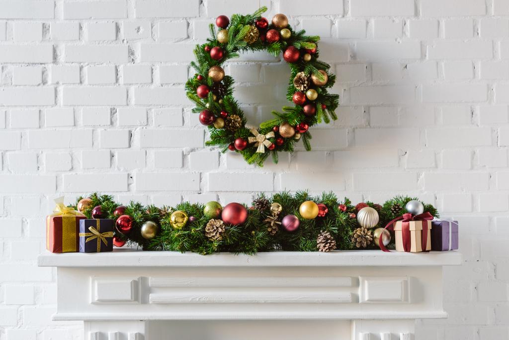 ghirlanda di Natale e decorazioni sopra camino caminetto con muro di mattoni bianchi
 - Foto, immagini