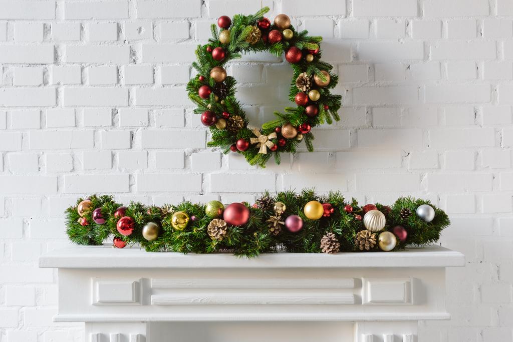 grinalda de Natal festiva sobre lareira mantel com parede de tijolo branco
 - Foto, Imagem