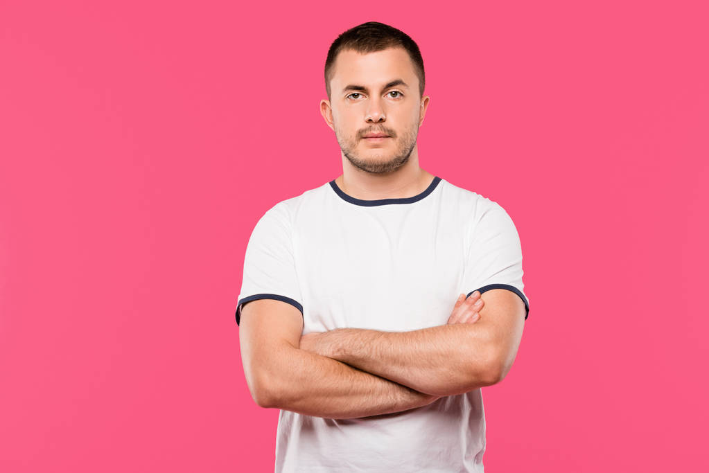 confident handsome young man posing with crossed arms isolated on pink - Photo, Image