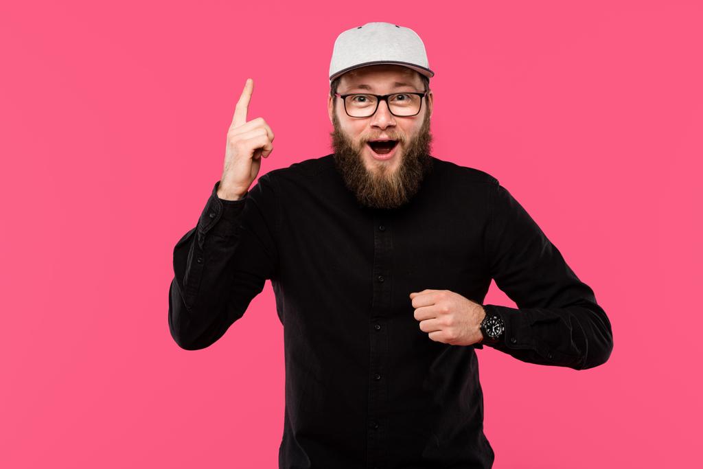 excited bearded man in eyeglasses and cap hat doing idea gesture isolated on pink - Photo, Image