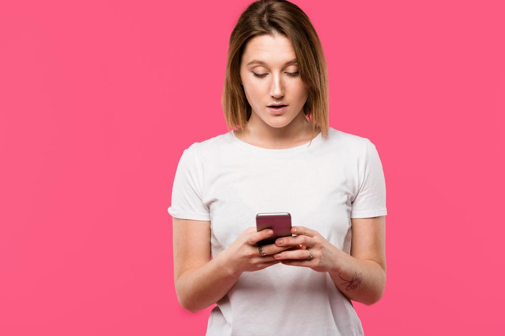 όμορφο κορίτσι χρησιμοποιώντας smartphone που απομονώνονται σε ροζ - Φωτογραφία, εικόνα