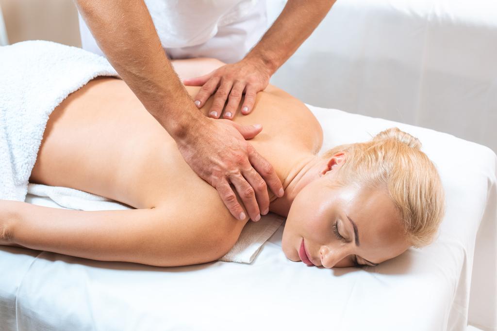 massagista do sexo masculino fazendo massagem para mulher loira
  - Foto, Imagem